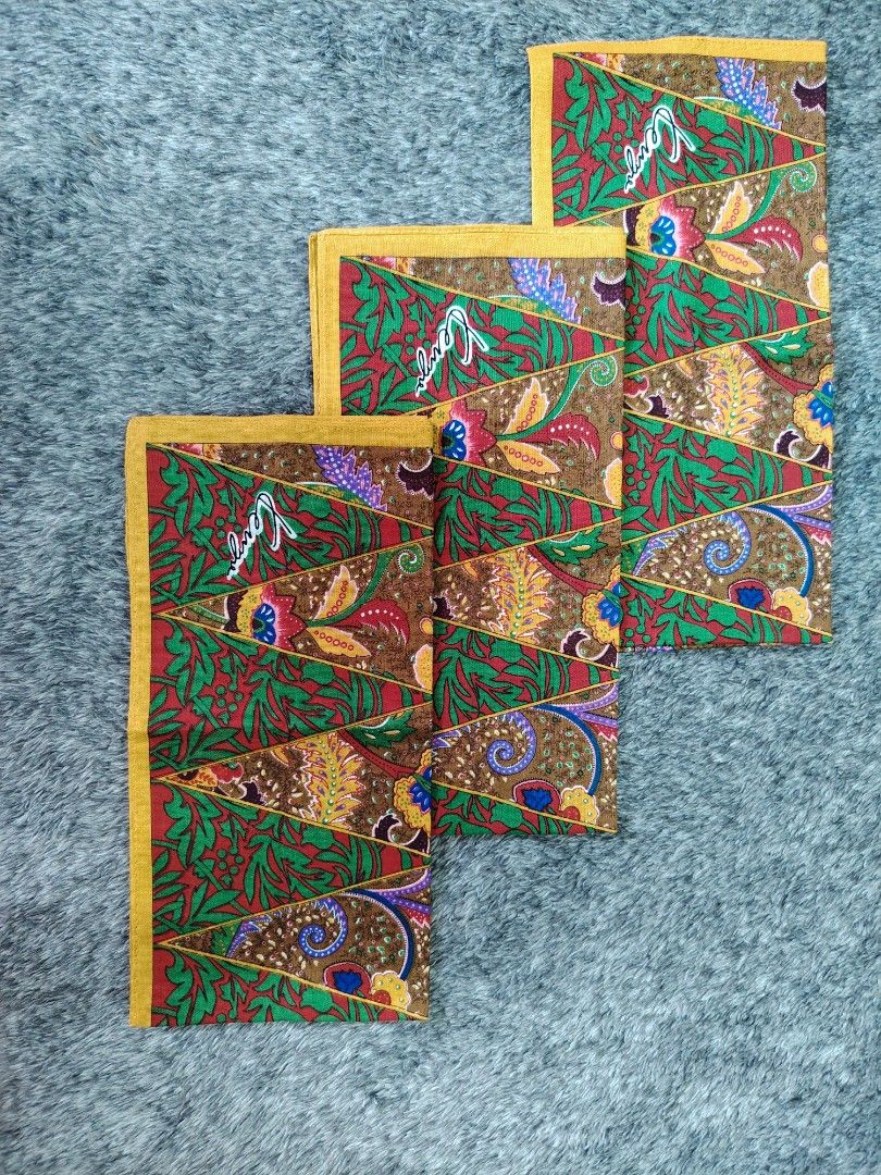 KENZO PANYO 180 each (Category: Handkerchief & Pocket Squares) located in Valenzuela. Submitted by anna.banana10 (Listing ID 1469094403, Image 1). Description: - Brand: Kenzo - Design: Traditional batik style with geometric triangular panels, floral, and paisley motifs - Colors: Green, red, brown, and yellow border - Details: Features signature Kenzo branding on the corner - Condition: Nice vintage accessory - Usage: Easy to fold and slip into a 