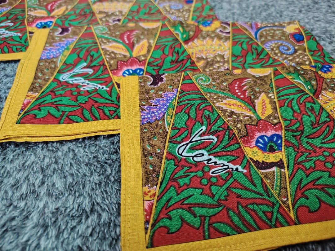 KENZO PANYO 180 each (Category: Handkerchief & Pocket Squares) located in Valenzuela. Submitted by anna.banana10 (Listing ID 1469094403, Image 2). Description: - Brand: Kenzo - Design: Traditional batik style with geometric triangular panels, floral, and paisley motifs - Colors: Green, red, brown, and yellow border - Details: Features signature Kenzo branding on the corner - Condition: Nice vintage accessory - Usage: Easy to fold and slip into a 