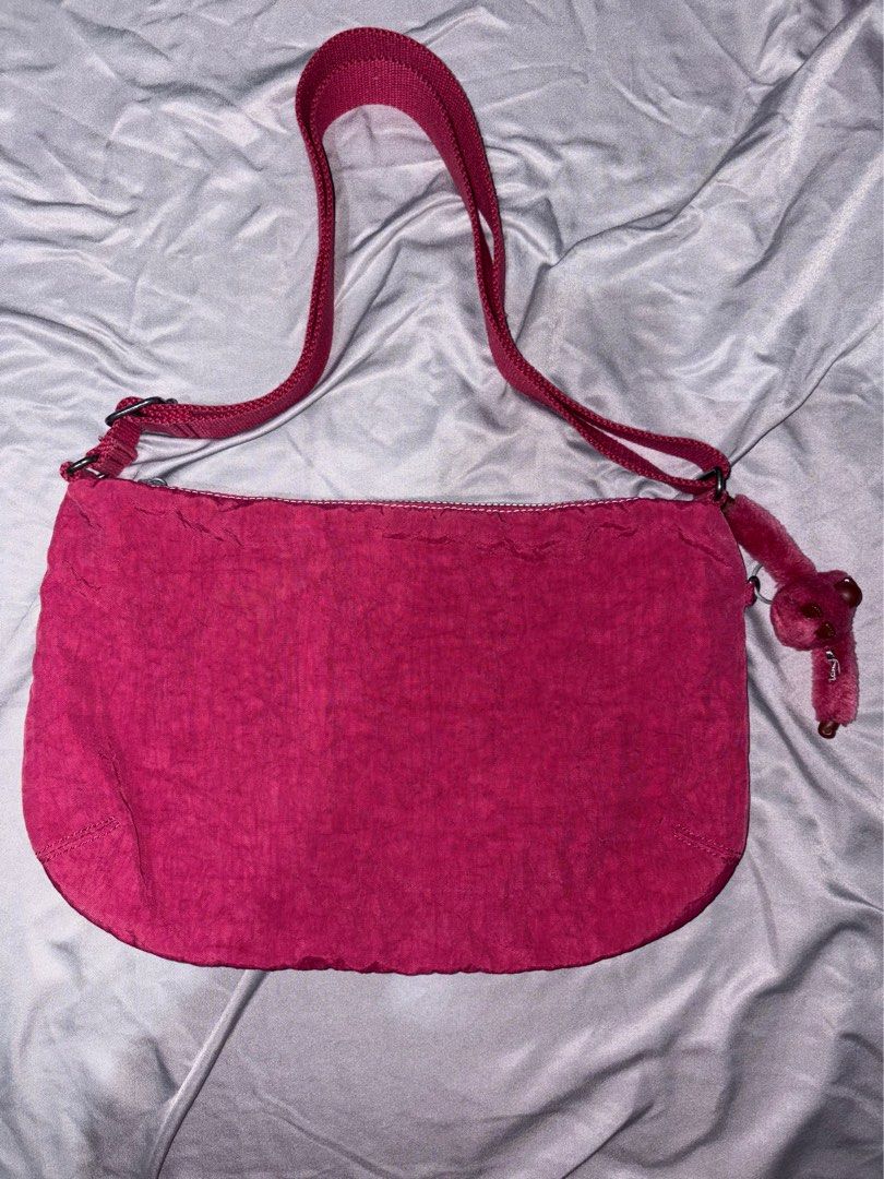 Kipling Berry Red Shoulder Bag (Category: Shoulder Bags) located in Taguig. Submitted by aliuy (Listing ID 1469103060, Image 2). Description: - Authentic Kipling shoulder bag - Color: Vibrant Berry Red - Material: Signature durable crinkled nylon - Dimensions: Approx. 14.5in x 10in - Strap length: max length 48in, min length 26in - Compartments: Secure main zippered compartment and zippered front section - Pockets: Two Velcro front pockets, plus 