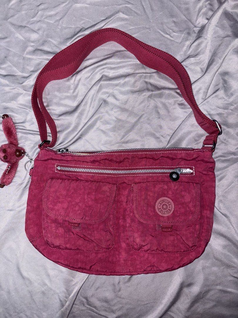 Kipling Berry Red Shoulder Bag (Category: Shoulder Bags) located in Taguig. Submitted by aliuy (Listing ID 1469103060, Image 1). Description: - Authentic Kipling shoulder bag - Color: Vibrant Berry Red - Material: Signature durable crinkled nylon - Dimensions: Approx. 14.5in x 10in - Strap length: max length 48in, min length 26in - Compartments: Secure main zippered compartment and zippered front section - Pockets: Two Velcro front pockets, plus 