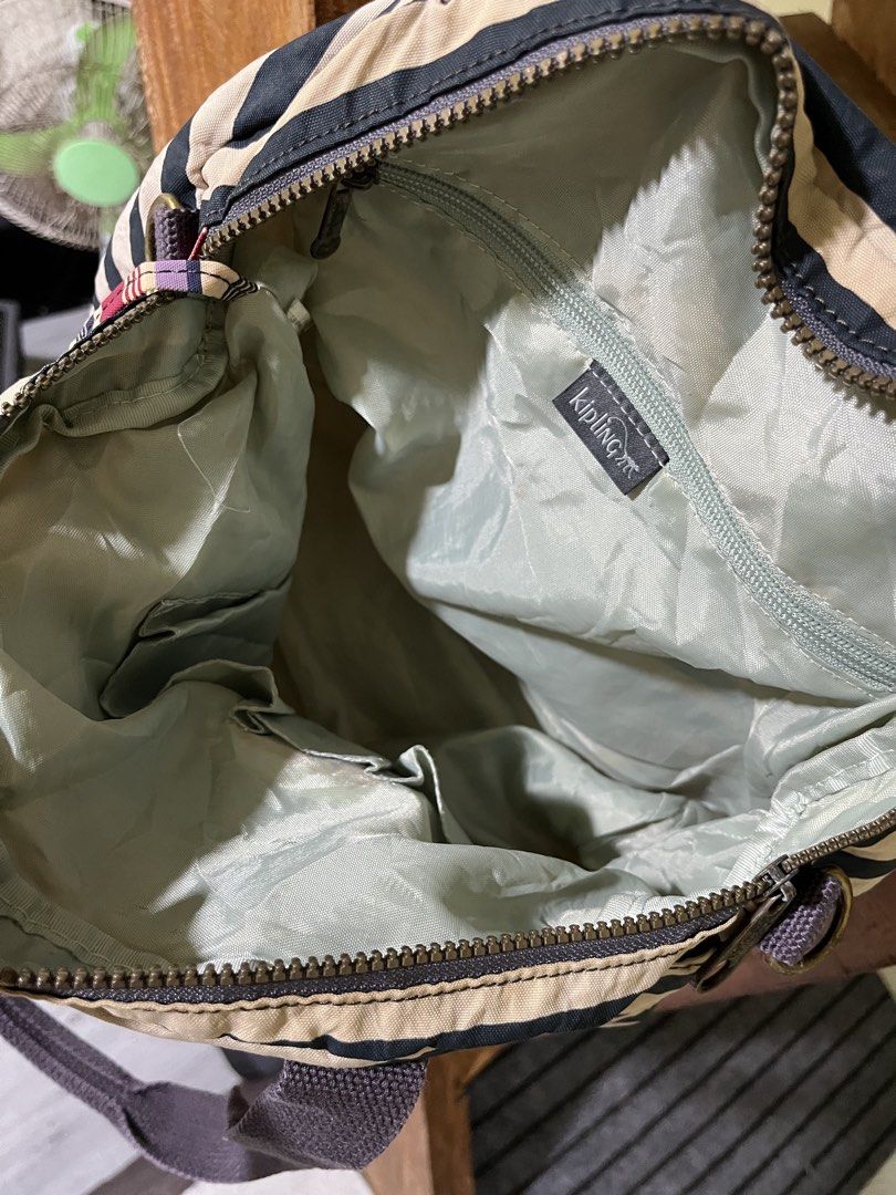 Kipling Black and Beige Striped Tote Bag (Category: Tote Bags) located in Carmen, Agusan del Norte. Submitted by all.en.thrifts (Listing ID 1469102542, Image 3). Description: - Brand: Kipling - Design: Classic black and beige stripes with front logo patch - Material: Durable, lightweight nylon - Compartments: Secure main zipped closure with vibrant light green inner lining - Pockets: Front zipped pocket and multiple inner pockets for easy organiz