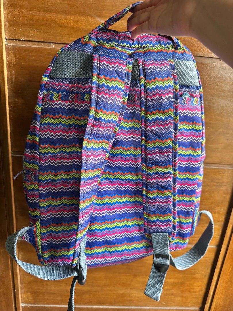Kipling Chevron Pattern Colorful Backpack (Category: Backpacks) located in Rizal. Submitted by mayra74 (Listing ID 1469094061, Image 2). Description: - Brand: Kipling - Design: Bright multi-color chevron zigzag pattern (blue, pink, yellow, and orange) - Exterior: Zip front pocket with round Kipling logo patch, grey adjustable straps, and top handle - Interior: Grey lining with circular Kipling logo design and a padded laptop sleeve with strap clo