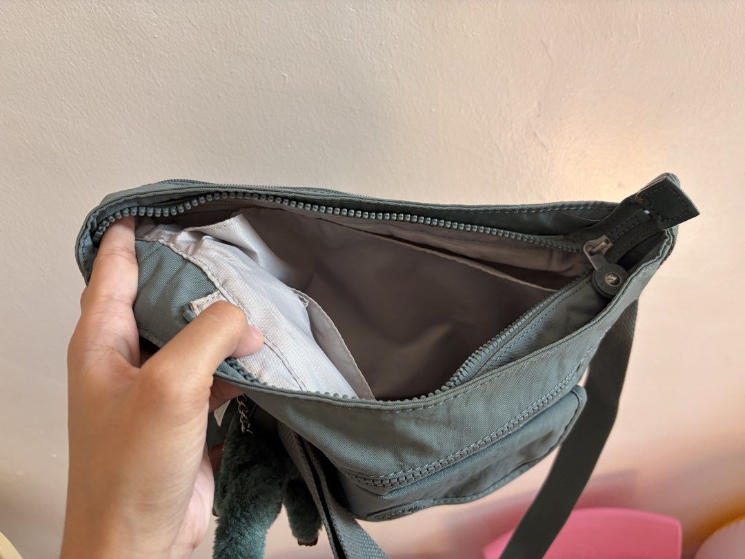 Kipling Grey Crossbody Bag with Monkey Keychain (Category: Cross-body Bags) located in Iloilo. Submitted by clariceanyanicole (Listing ID 1468933995, Image 3). Description: - Brand: Kipling Crossbody Bag - Color: Sage Grey - Material: Durable, lightweight nylon - Exterior: Zipped front pocket, flap pocket with signature round logo patch - Interior: Spacious main compartment with convenient slip pockets - Strap: Adjustable crossbody strap for cust