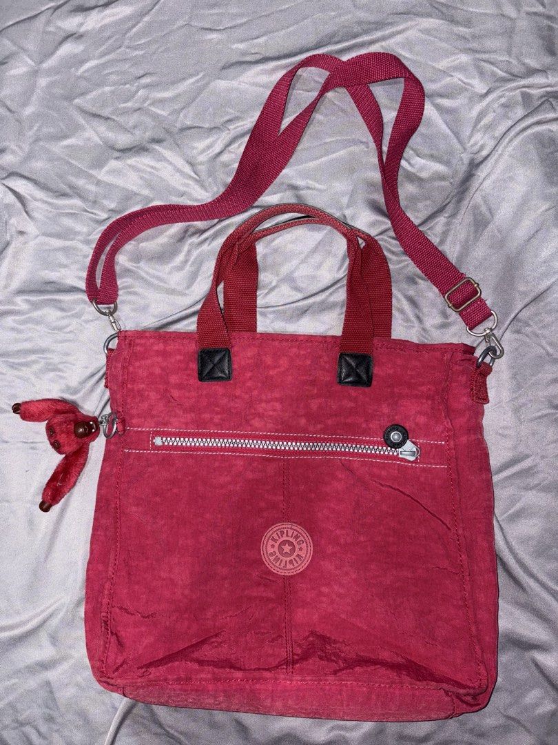 Kipling red bag (Category: Tote Bags) located in Taguig. Submitted by aliuy (Listing ID 1469103476, Image 1). Description: Nice as school or office bag, has pockets for pens and other knick knacks Approximate strap length (inches): - min: 27 - max: 52.5 Authentic Kipling bag Rfs: decluttering ▪️Shipping via J&T or Grab Express/Lalamove for MNL area; J&T for provinces ▪️No Shope.e checkout ▪️Location of item: Taguig ▪️Available as long as posted ▪