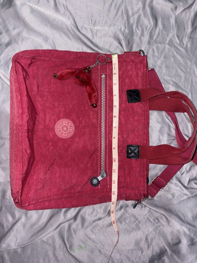 Kipling red bag (Category: Tote Bags) located in Taguig. Submitted by aliuy (Listing ID 1469103476, Image 3). Description: Nice as school or office bag, has pockets for pens and other knick knacks Approximate strap length (inches): - min: 27 - max: 52.5 Authentic Kipling bag Rfs: decluttering ▪️Shipping via J&T or Grab Express/Lalamove for MNL area; J&T for provinces ▪️No Shope.e checkout ▪️Location of item: Taguig ▪️Available as long as posted ▪