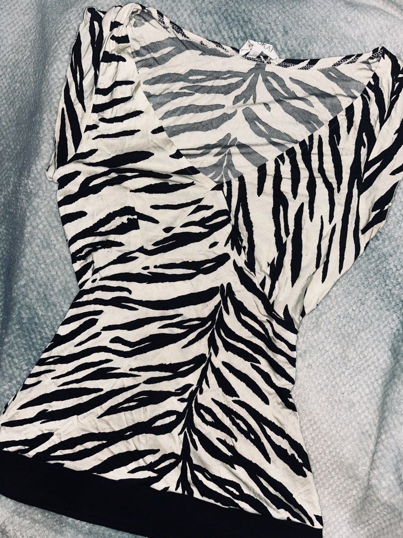 Kookai Zebra Print Wrap Top Size 1 (Category: Blouses) located in Dagupan City. Submitted by shanadongsb (Listing ID 1469123227, Image 2). Description: - Brand: Kookai (Paris label) - Style: Zebra print V-neck wrap front top with short sleeves and solid black bottom hem - Size: 1 (Tag attached) - Material: 100% rayon - Features: Lightweight, breathable fabric with a beautiful drape - Color: Classic black and white.