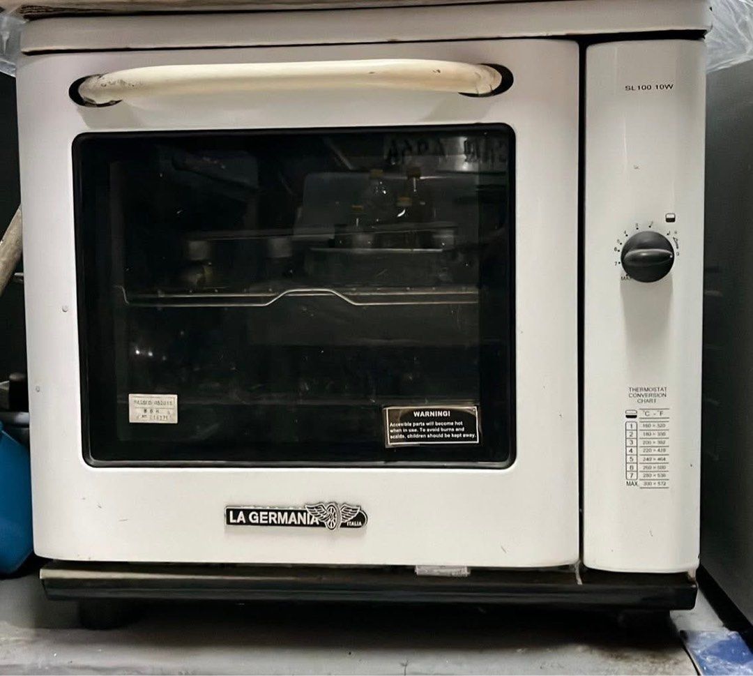 La Germania SL100 10W White Oven (Category: Ovens & Toasters) located in Manila. Submitted by lykaaaa2413 (Listing ID 1468969857, Image 3). Description: - Brand/Model: La Germania SL100 10W Oven - Color: Classic White - Design: Countertop oven with standard pull-down glass door and large white handle - Controls: Side control knobs with printed temperature conversion chart - Inclusions: Wire racks and baking trays - Condition: Working great, perfe
