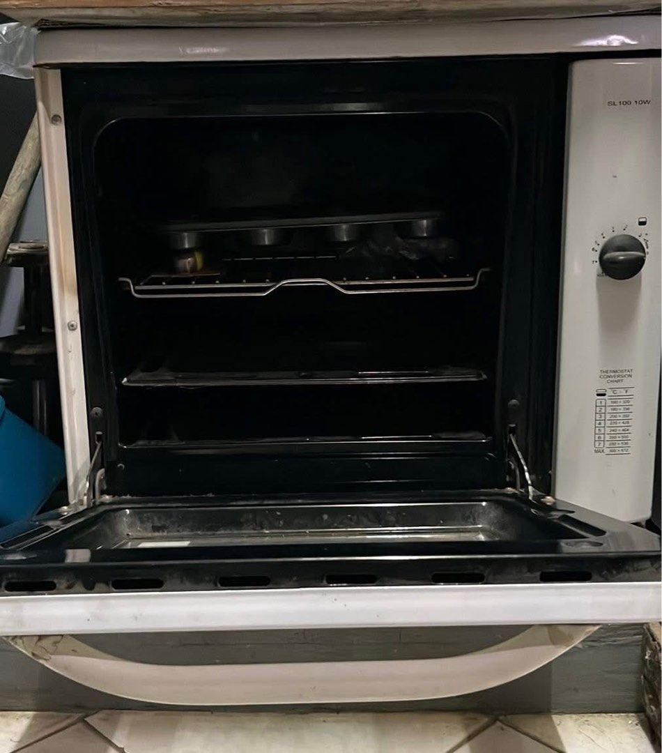 La Germania SL100 10W White Oven (Category: Ovens & Toasters) located in Manila. Submitted by lykaaaa2413 (Listing ID 1468969857, Image 2). Description: - Brand/Model: La Germania SL100 10W Oven - Color: Classic White - Design: Countertop oven with standard pull-down glass door and large white handle - Controls: Side control knobs with printed temperature conversion chart - Inclusions: Wire racks and baking trays - Condition: Working great, perfe