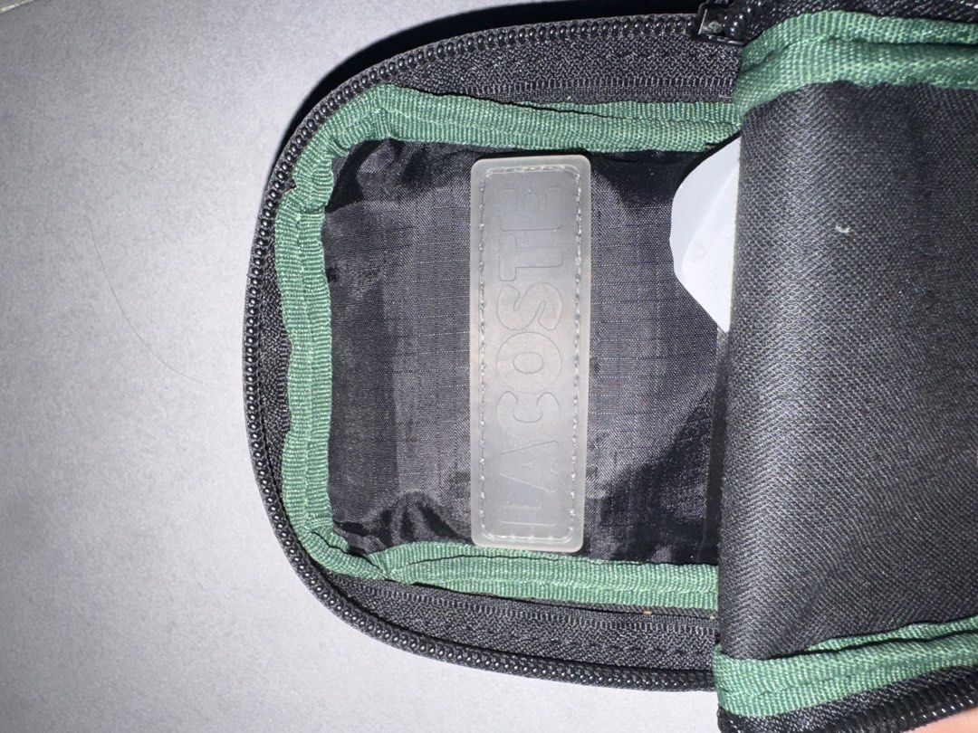Lacoste Black Crossbody Sling Bag (Category: Sling Bags) located in Caloocan City. Submitted by gabbieerfritter (Listing ID 1469032039, Image 3). Description: - Authentic Black Lacoste Crossbody Bag - Durable textured PVC material with matching care tag - Secure zip closure featuring an embossed crocodile logo pull - Adjustable strap for a comfortable, custom fit - Vibrant green fabric interior lining with classic Lacoste logo patch - Compact and