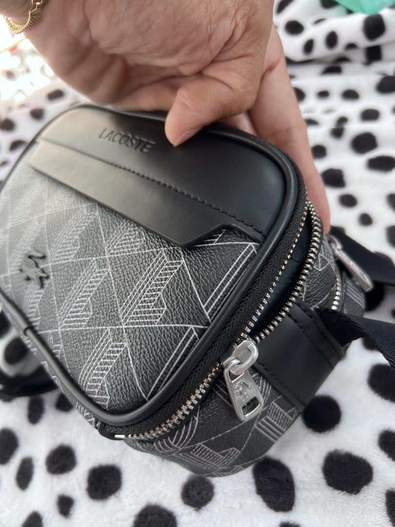 Lacoste Black Monogram Crossbody Bag (Category: Sling Bags) located in Rizal. Submitted by imallari88 (Listing ID 1469005990, Image 3). Description: - Authentic Lacoste crossbody bag in sleek black with a geometric monogram pattern - Durable PVC exterior with smooth black leather front trim and embossed branding - Eye-catching vibrant orange interior lining with multiple compartments and inner tag - Silver-tone metal zippers featuring iconic smal