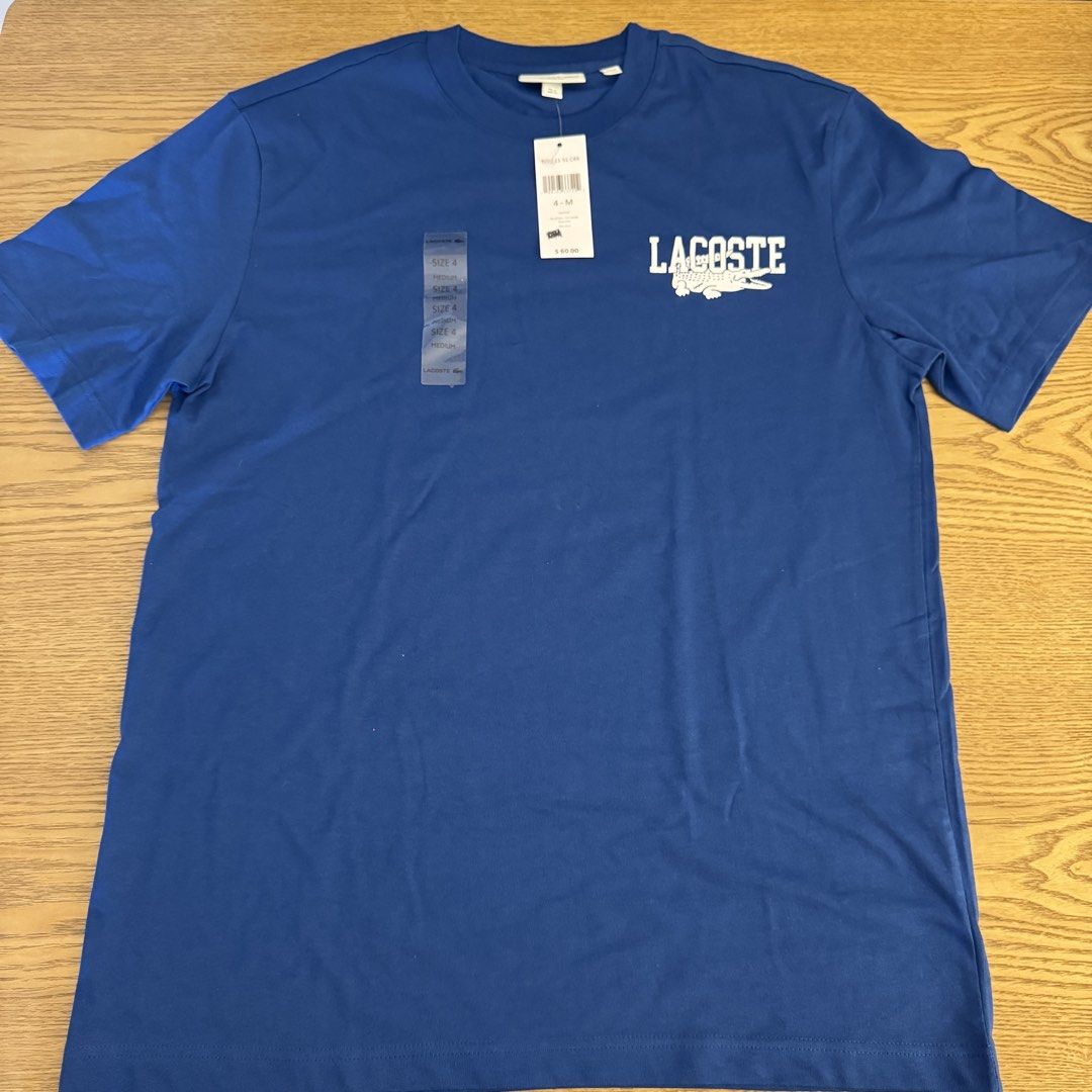 Lacoste Blue C4X Graphic T-Shirt Size 4 Medium (Category: Tshirts & Polo Shirts ) located in Pasig City. Submitted by mon.alcantara (Listing ID 1468931986, Image 1). Description: - Brand: Lacoste Blue C4X - Style: Crew neck tee - Material: 100% Cotton - Size: 4 (Medium) - Condition: Brand new with original store tag attached - Design: Graphic text on the front, and small embroidered logo patch at the back neckline - No paper bag, no box, just the