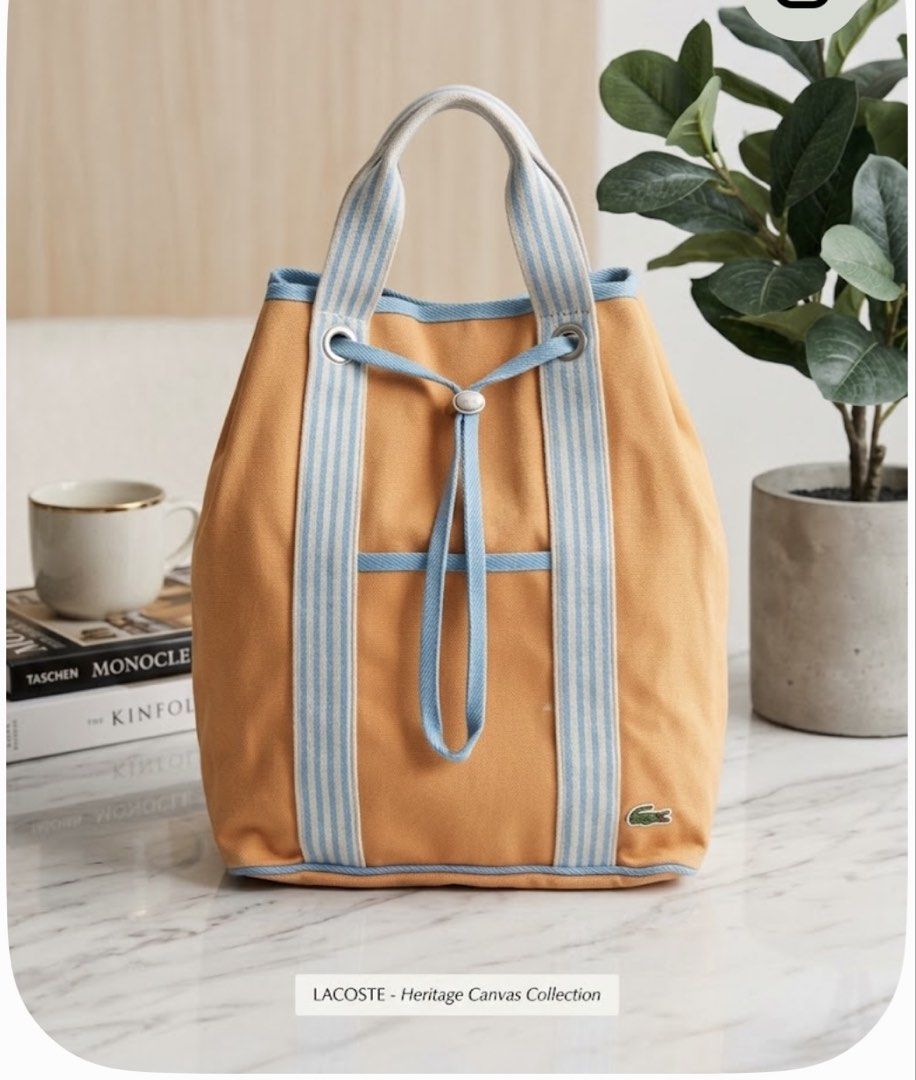 Lacoste Heritage Canvas Collection Tote Bag (Category: Tote Bags) located in Manila. Submitted by goldenphoenix_ac6904 (Listing ID 1468964514, Image 1). Description: - Authentic Lacoste canvas tote bag in vibrant yellow - Chic light blue and white striped dual top handles - Secure drawstring closure with stylish metal eyelets - Structured design that stands up on its own - Spacious interior perfect for daily essentials - Signature embroidered Lac