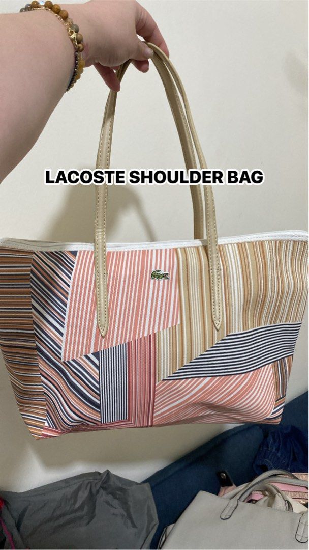 Lacoste Multicolored Striped Tote Shoulder Bag (Category: Tote Bags) located in Silang. Submitted by princess_jasmin (Listing ID 1469105459, Image 1). Description: - Brand: Lacoste - Design: Multicolored stripes with geometric panels - Straps: Cream shoulder straps - Details: Classic green crocodile logo on the front - Interior: Spacious canvas material, ideal for daily essentials - Closure: Secure zipper top closure - Condition: Clean and well-m