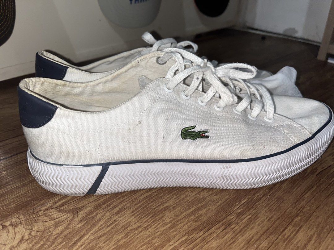 Lacoste White Canvas Sneakers (Category: Sneakers) located in San Pablo. Submitted by crazyr17 (Listing ID 1468971000, Image 2). Description: - Brand: Lacoste - Color: White canvas with dark navy heel tabs and green crocodile embroidery - Closure: Traditional lace-up with white laces - Comfort: OrthoLite insoles for all-day wear - Soles: Textured rubber with black and dark navy contrast inserts - Condition: Normal signs of wear on fabric and sole
