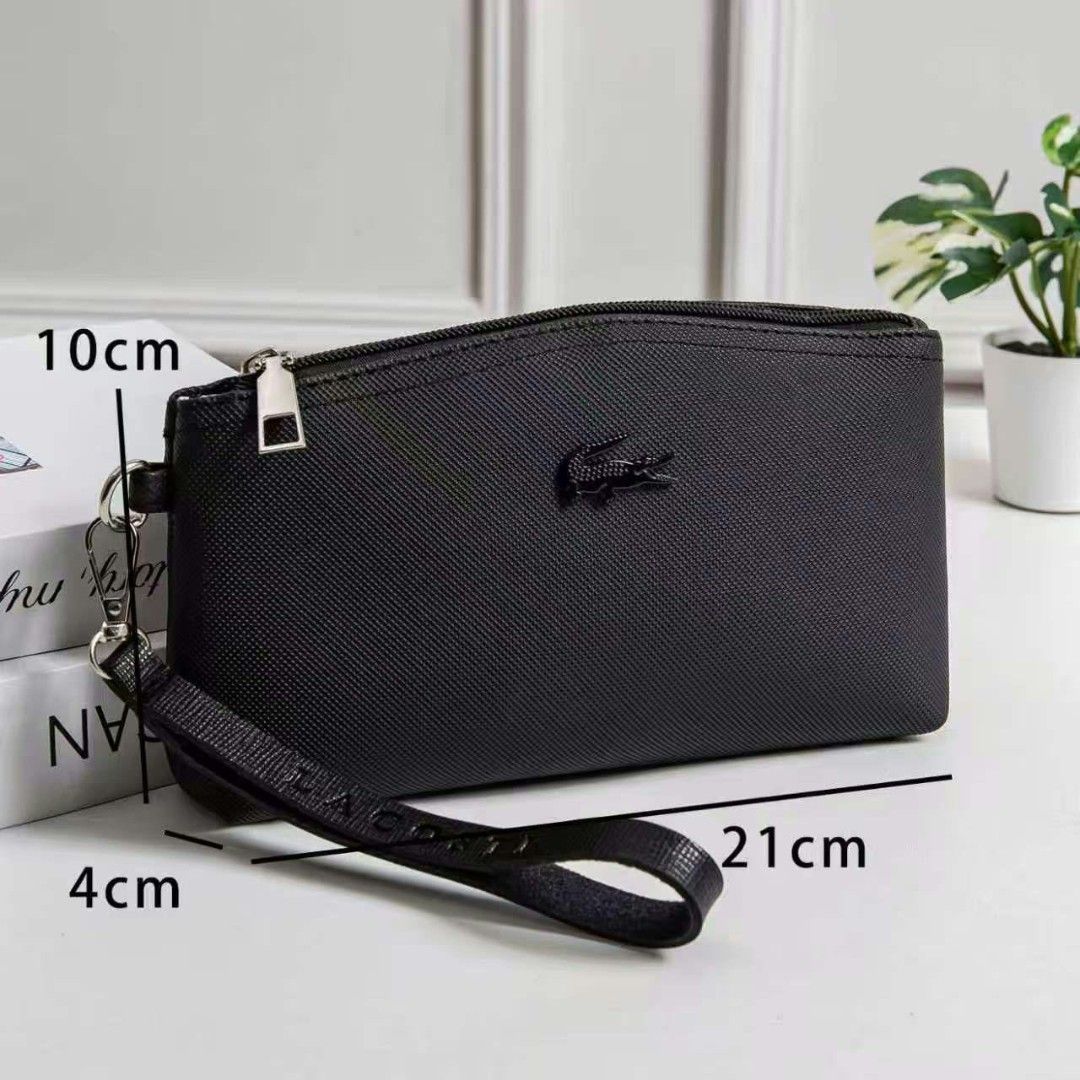 Lacoste Wristlet Pouch Multiple Colors Available 21cm x 10cm (Category: Purses & Pouches) located in Manila. Submitted by jonalyn19 (Listing ID 1468946906, Image 3). Description: - Brand: Lacoste - Style: Textured wristlet pouch with iconic front crocodile logo - Dimensions: 21cm (L) x 10cm (H) x 4cm (W) - Closure & Strap: Top zipper closure with matching wrist strap featuring embossed lettering - Interior: Lined, spacious enough for a phone, key