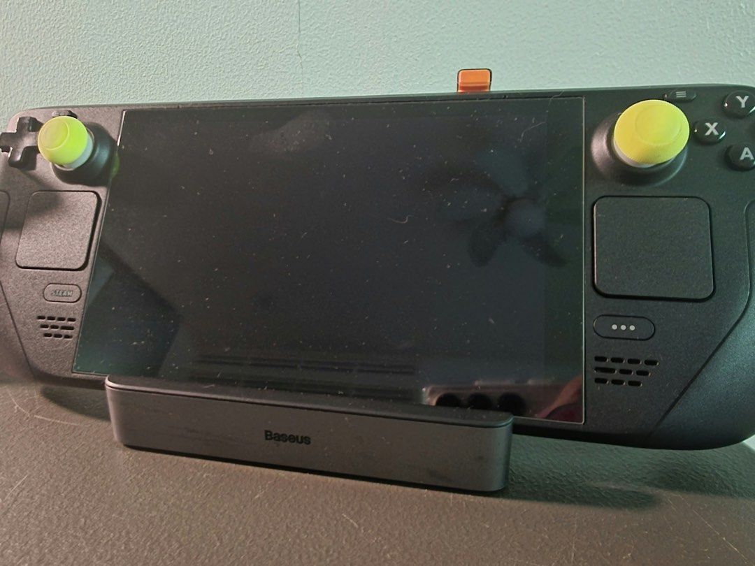 LCD Steam Deck with Baseus Docking Station (Category: Controllers) located in Manila. Submitted by marie_moon (Listing ID 1468979971, Image 2). Description: - LCD handheld console with Baseus dock included - Equipped with stylish yellow thumb grips on both joysticks - Tested and fully functional for handheld or docked gaming - Screen displays Skyrim library interface, ready to play - Minor dust accumulation on the plastic casing.