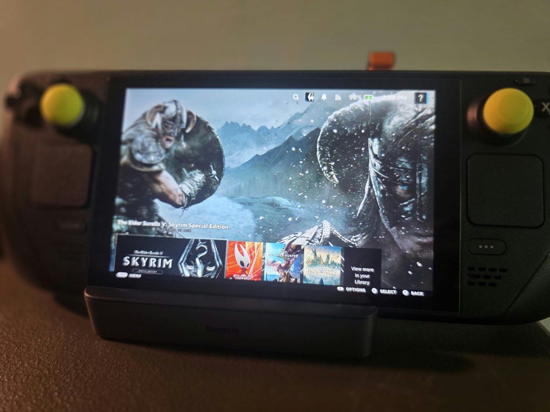 LCD Steam Deck with Baseus Docking Station (Category: Controllers) located in Manila. Submitted by marie_moon (Listing ID 1468979971, Image 1). Description: - LCD handheld console with Baseus dock included - Equipped with stylish yellow thumb grips on both joysticks - Tested and fully functional for handheld or docked gaming - Screen displays Skyrim library interface, ready to play - Minor dust accumulation on the plastic casing.