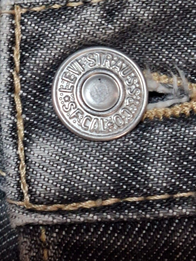 Levi Strauss & Co. Black Denim Jeans (Category: Jeans) located in Baguio. Submitted by restyrille77846 (Listing ID 1468998709, Image 2). Description: - Brand: Levi Strauss & Co. - Color: Classic Black - Closure: Button fly with branded metal buttons - Fit: Straight leg cut with traditional five-pocket styling - Condition: Good pre-loved condition with natural fraying and wear along the bottom hems.