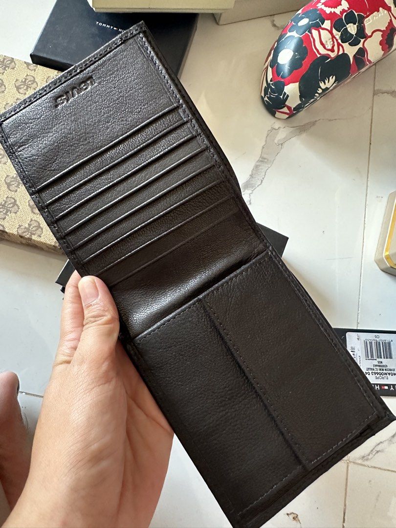 Levi's Leather Bifold Wallet (Category: Wallets & Card Holders) located in Vinzons. Submitted by melodylarg85741 (Listing ID 1468977741, Image 2). Description: Dark brown leather wallet from Levi's. Multiple card slots inside, plus a bill compartment. Metal logo button on the front. Clean interior lining with tag attached. Sturdy construction, classic design..