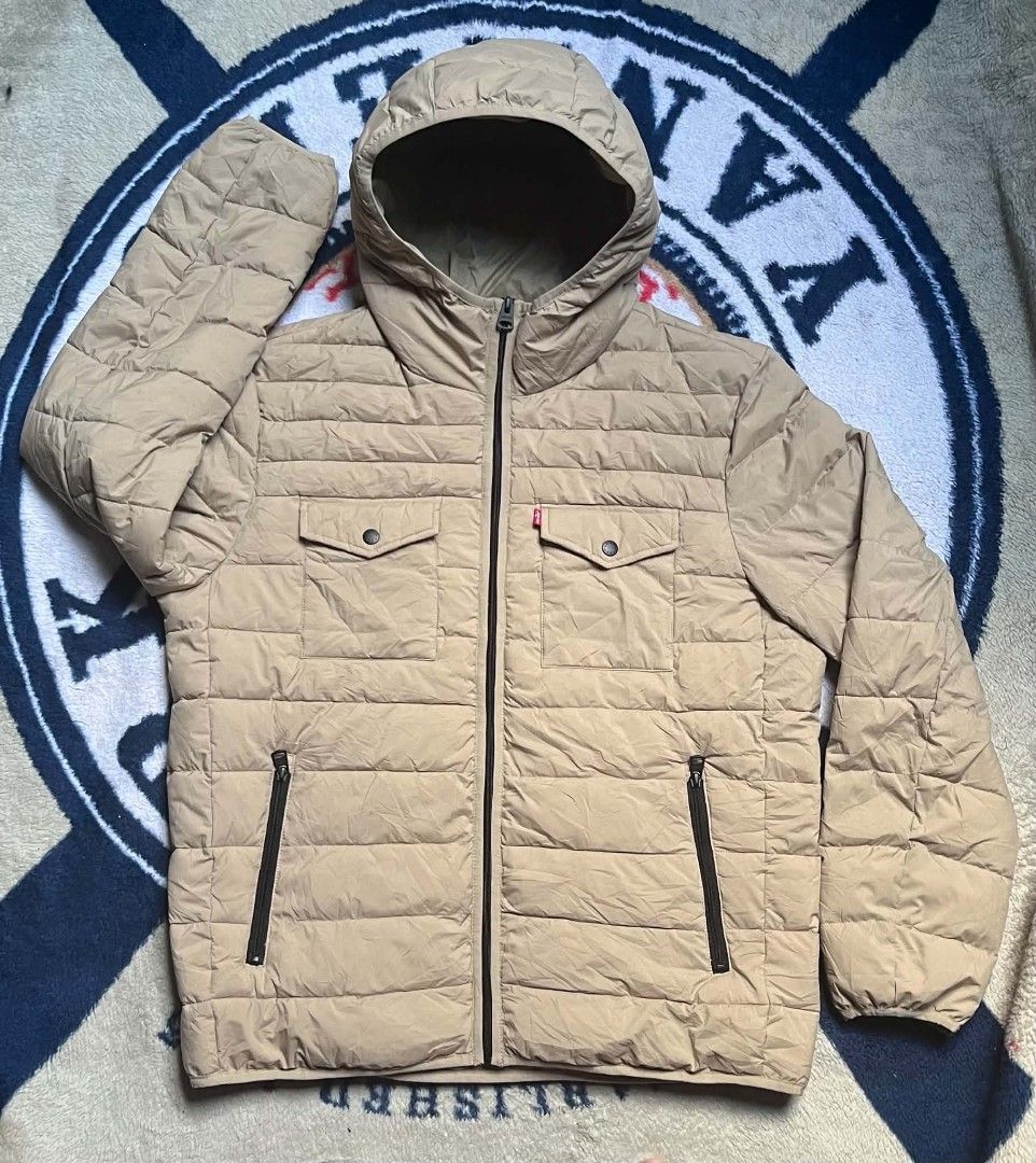 Levi's Quilted Puffer Hooded Jacket Beige (Category: Coats, Jackets and Outerwear) located in Manila. Submitted by dildojrjon00316 (Listing ID 1468998845, Image 1). Description: - Brand: Levi's - Color: Classic Beige - Style: Quilted puffer jacket with attached hood - Closure: Full front zip - Pockets: 2 snap-button chest pockets with red tab, 2 zippered lower hand pockets, and 1 inner pocket - Details: Elastic cuffs for extra warmth and snug fit