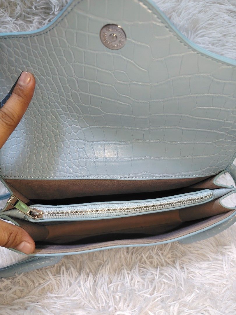 Light Blue Croc Embossed Shoulder Bag (Category: Shoulder Bags) located in Quezon City. Submitted by zhelcloset01 (Listing ID 1469063598, Image 3). Description: - Color: Light blue - Material/Texture: Trendy all-over croc-embossed design - Closure: Secure front flap with a magnetic snap button - Straps: Comfortable double shoulder straps - Interior: Clean lining with a handy zippered divider pocket - Capacity: Very spacious and ideal for daily es