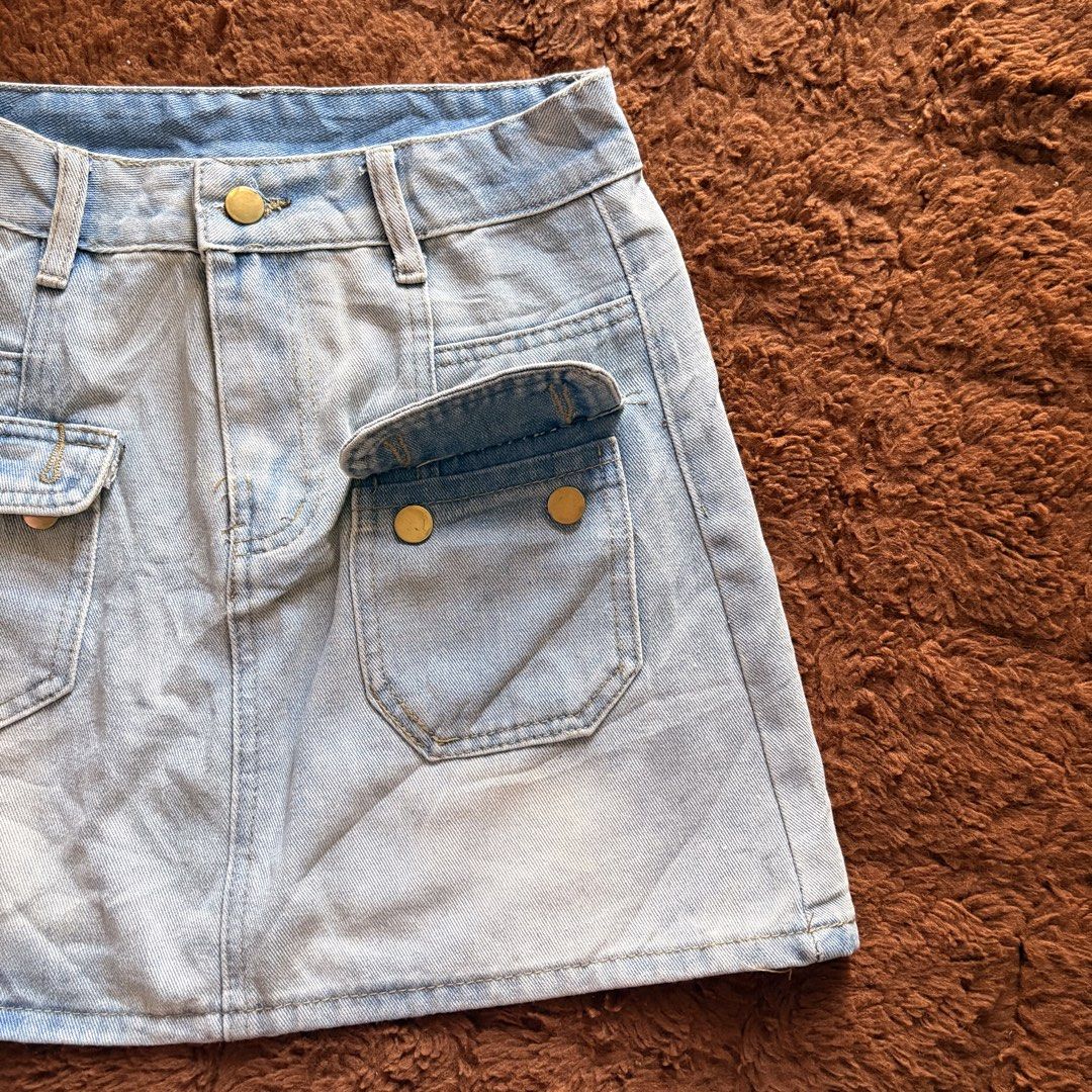 Light wash denim mini skirt with front pockets (Category: Skirts) located in Makati City. Submitted by jinlouise (Listing ID 1468933750, Image 2). Description: - Style: Classic high-waisted denim mini skirt - Color: Light blue wash with gold-toned hardware - Pockets: Two front flap pockets and two regular back pockets - Features: Belt loops and short length - Versatility: Great for casual outings, easy to pair with basic tees or crop tops - size: