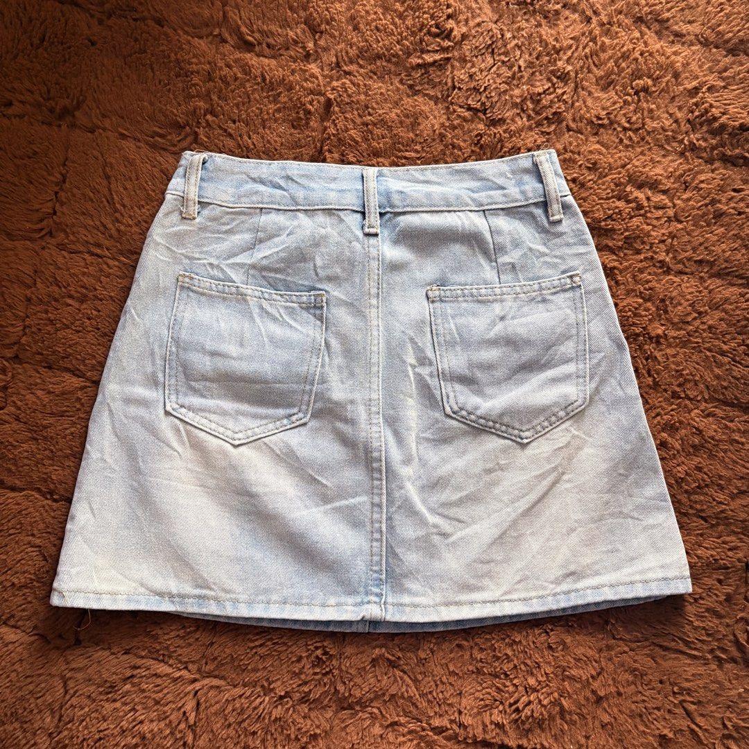 Light wash denim mini skirt with front pockets (Category: Skirts) located in Makati City. Submitted by jinlouise (Listing ID 1468933750, Image 3). Description: - Style: Classic high-waisted denim mini skirt - Color: Light blue wash with gold-toned hardware - Pockets: Two front flap pockets and two regular back pockets - Features: Belt loops and short length - Versatility: Great for casual outings, easy to pair with basic tees or crop tops - size: