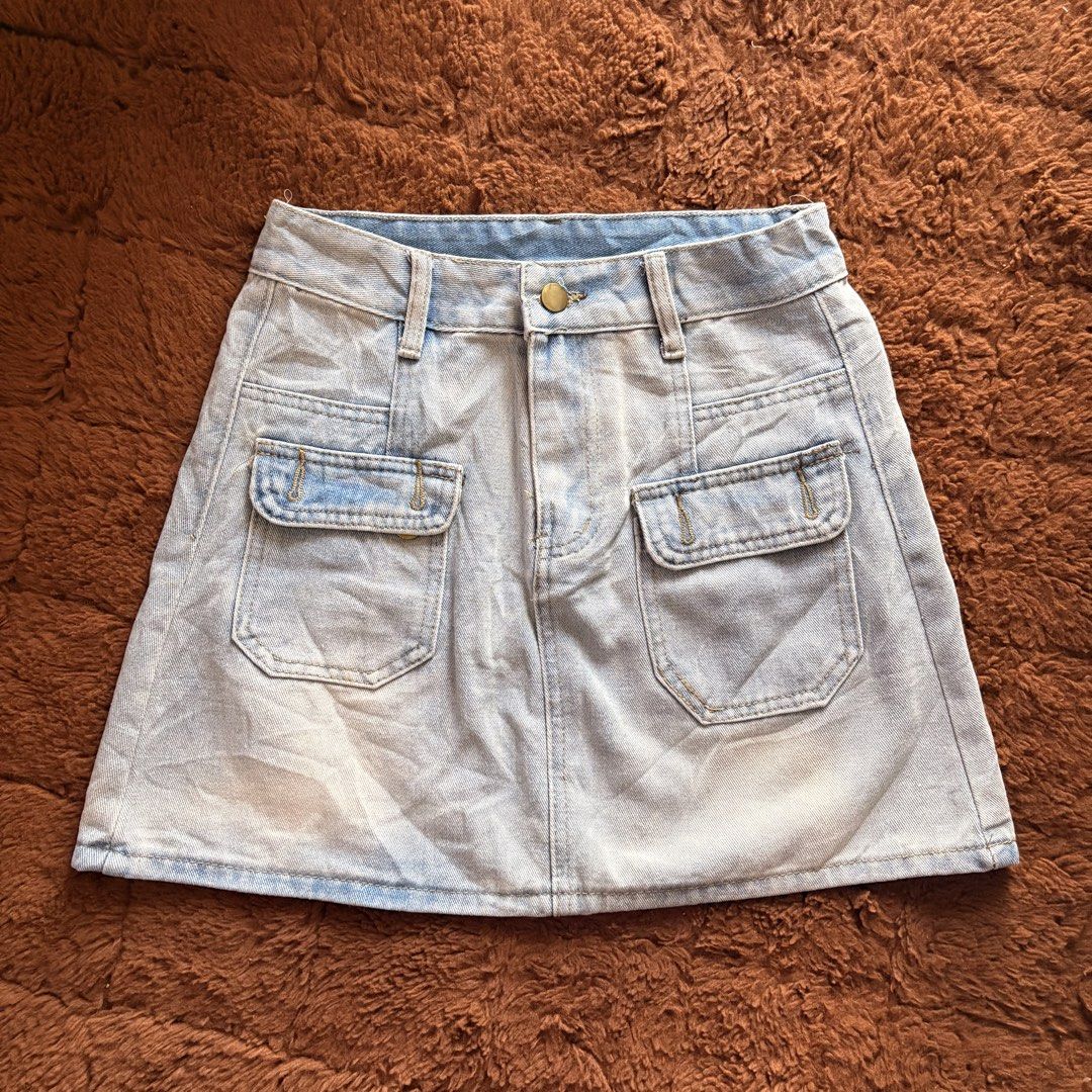 Light wash denim mini skirt with front pockets (Category: Skirts) located in Makati City. Submitted by jinlouise (Listing ID 1468933750, Image 1). Description: - Style: Classic high-waisted denim mini skirt - Color: Light blue wash with gold-toned hardware - Pockets: Two front flap pockets and two regular back pockets - Features: Belt loops and short length - Versatility: Great for casual outings, easy to pair with basic tees or crop tops - size: