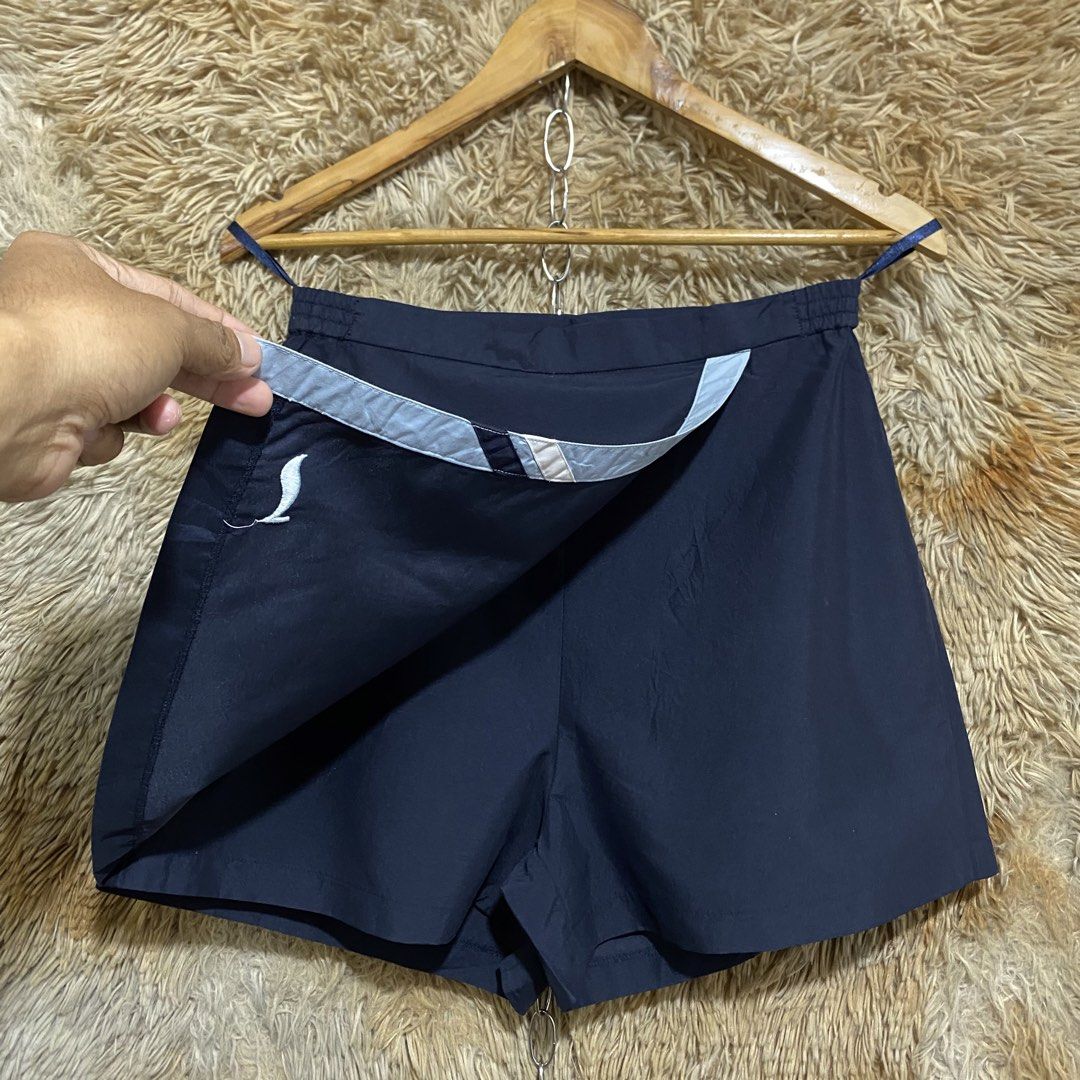 Li-Ning Navy Blue Skort Size L (Category: Skirts) located in Butuan. Submitted by jc13thrifts (Listing ID 1469060334, Image 3). Description: - Brand: Li-Ning - Color: Navy blue with contrast light blue vertical stripe and logo - Size: L - Features: Built-in shorts underneath for active movement, elastic waistband at the back with button and zip closure, and a back pocket with button detail - Condition: Excellent.