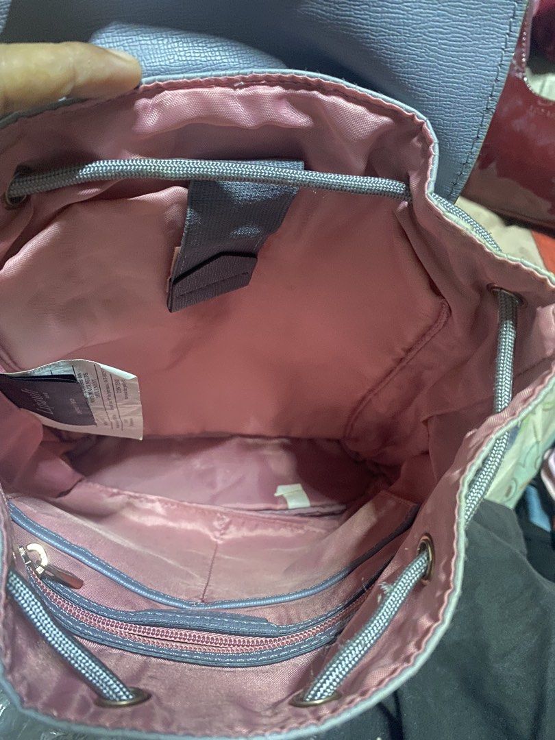Lipault Paris Light Grey Backpack (Category: Backpacks) located in Manila. Submitted by noemiaspa1702 (Listing ID 1469079784, Image 2). Description: - Authentic Lipault Paris backpack - Color: Light grey with vibrant pink interior lining - Closure: Flap top with secure metal clasp and drawstring pull - Storage: Multiple interior pockets, including a zippered compartment and a velcro tab pocket - Comfort: Adjustable shoulder straps for a custom fi