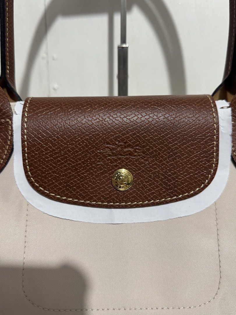 Longchamp Le Pliage Tote Bag (Category: Luxury Bags & Wallets) located in Manila. Submitted by reinjoseph (Listing ID 1468985738, Image 2). Description: - Authentic Longchamp Le Pliage tote bag - Color: Classic beige with brown leather handles and flap - Hardware: Gold-tone snap button with embossed horse logo - Model: L2605089P71 (Made in China) - Condition: Brand new with original tags still attached - Features: Spacious interior, durable nylon