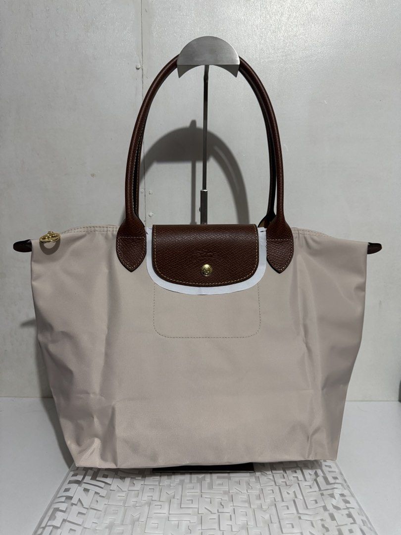 Longchamp Le Pliage Tote Bag (Category: Luxury Bags & Wallets) located in Manila. Submitted by reinjoseph (Listing ID 1468985738, Image 1). Description: - Authentic Longchamp Le Pliage tote bag - Color: Classic beige with brown leather handles and flap - Hardware: Gold-tone snap button with embossed horse logo - Model: L2605089P71 (Made in China) - Condition: Brand new with original tags still attached - Features: Spacious interior, durable nylon
