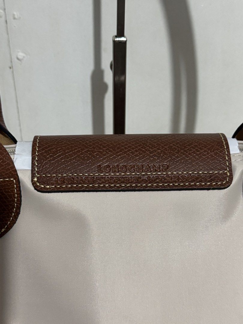 Longchamp Le Pliage Tote Bag (Category: Luxury Bags & Wallets) located in Manila. Submitted by reinjoseph (Listing ID 1468985738, Image 3). Description: - Authentic Longchamp Le Pliage tote bag - Color: Classic beige with brown leather handles and flap - Hardware: Gold-tone snap button with embossed horse logo - Model: L2605089P71 (Made in China) - Condition: Brand new with original tags still attached - Features: Spacious interior, durable nylon