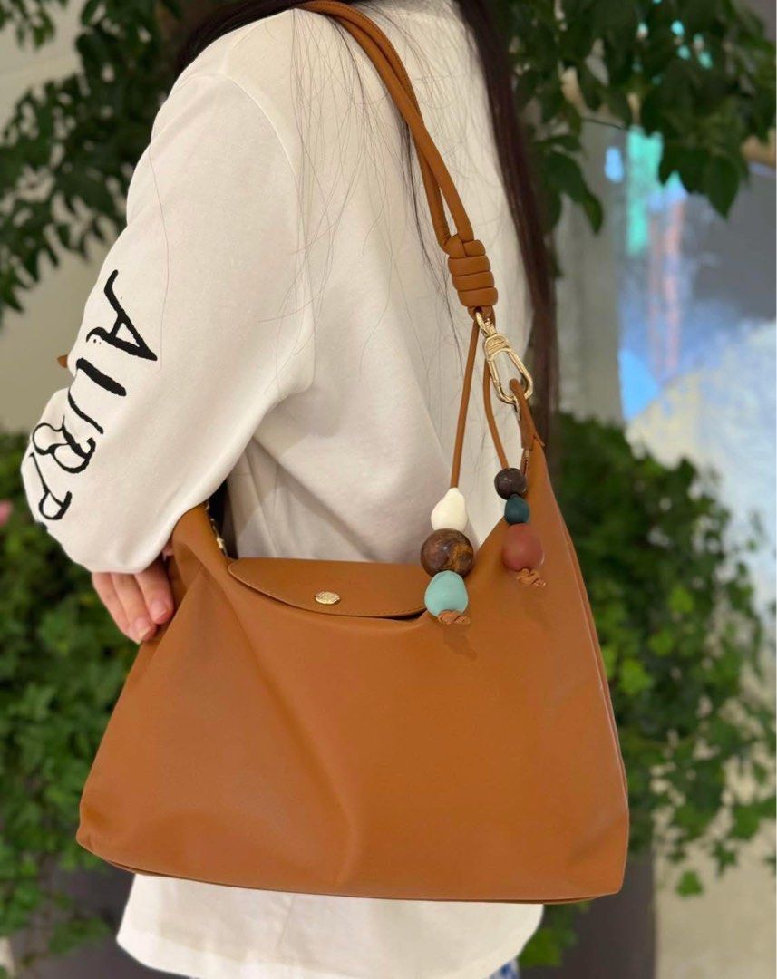 Longchamp Leather Shoulder Bag with charms (Category: Shoulder Bags) located in Abulug. Submitted by jamiecammie (Listing ID 1468993840, Image 1). Description: - Brand: Longchamp - Material: Genuine brown leather with clean exterior - Closure: Flap with gold snap button and debossed horse logo, plus a secure zippered top compartment Original.