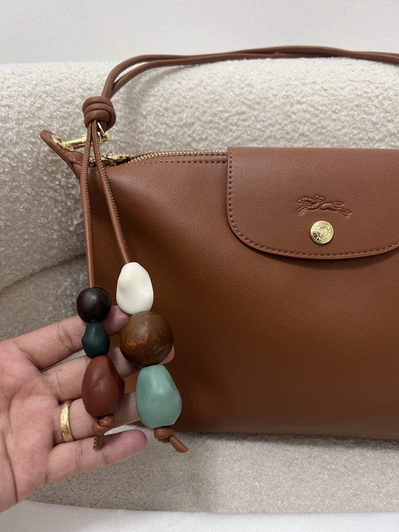 Longchamp Leather Shoulder Bag with charms (Category: Shoulder Bags) located in Abulug. Submitted by jamiecammie (Listing ID 1468993840, Image 3). Description: - Brand: Longchamp - Material: Genuine brown leather with clean exterior - Closure: Flap with gold snap button and debossed horse logo, plus a secure zippered top compartment Original.