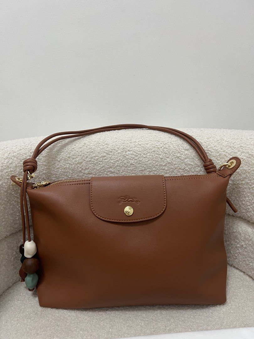 Longchamp Leather Shoulder Bag with charms (Category: Shoulder Bags) located in Abulug. Submitted by jamiecammie (Listing ID 1468993840, Image 2). Description: - Brand: Longchamp - Material: Genuine brown leather with clean exterior - Closure: Flap with gold snap button and debossed horse logo, plus a secure zippered top compartment Original.