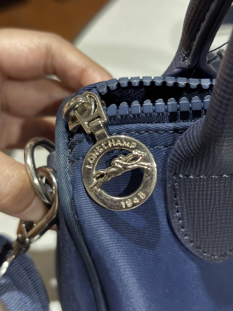 Longchamp navy small doctor's bag (Category: Cross-body Bags) located in Manila. Submitted by bbygirly (Listing ID 1469102637, Image 3). Description: - NGA, Preloved only - Super cute~ Barrel le pliage satchel style - Used twice but stained na pls see pic! - Adjustable strap tags: longchamp, office siren, y2k, vintage.