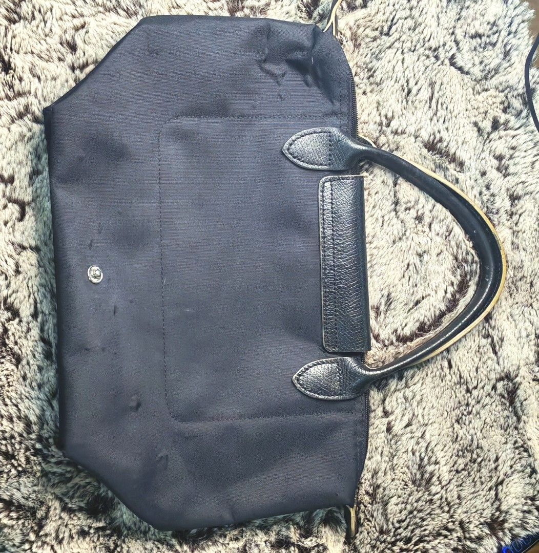 Longchamp Paris Tote Bag black (Category: Luxury Bags & Wallets) located in Caloocan City. Submitted by miyaka_lm (Listing ID 1469088526, Image 2). Description: - Authentic Longchamp tote bag in d - Medium size, ideal for daily use - Classic durable nylon body with leather flap closure and handles - Elegant gold-tone hardware and snap button - Signature embroidered jockey logo on the front - Interior tag shows model details and origin - Condition
