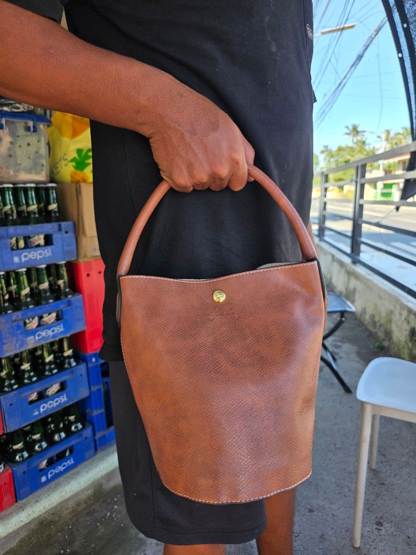 Longchamp Épure Bucket Bag Brown (Category: Shoulder Bags) located in Lemery. Submitted by venus23 (Listing ID 1468931642, Image 1). Description: - Brand: Longchamp Épure - Color: Brown - Material: Premium textured leather - Design: Structured bucket bag with a round base and sturdy top handle - Hardware: Gold-tone snap button closure with embossed horse logo - Interior: Clean lining with neat stitching throughout - Capacity: Compact size that ea