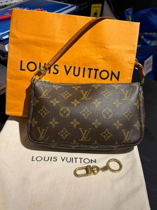 Louis Vuitton Monogram Accessoires Pochette Handbag (Category: Luxury Bags & Wallets) located in Quezon City. Submitted by luxuriesbymichiika (Listing ID 1469151935, Image 1). Description: - Authentic Louis Vuitton monogram canvas pouch - Classic brown leather strap and gold hardware - Secure top zip closure for daily essentials or evening outings - Includes original dust bag, iconic orange shopping bag, and a matching gold key ring hook.