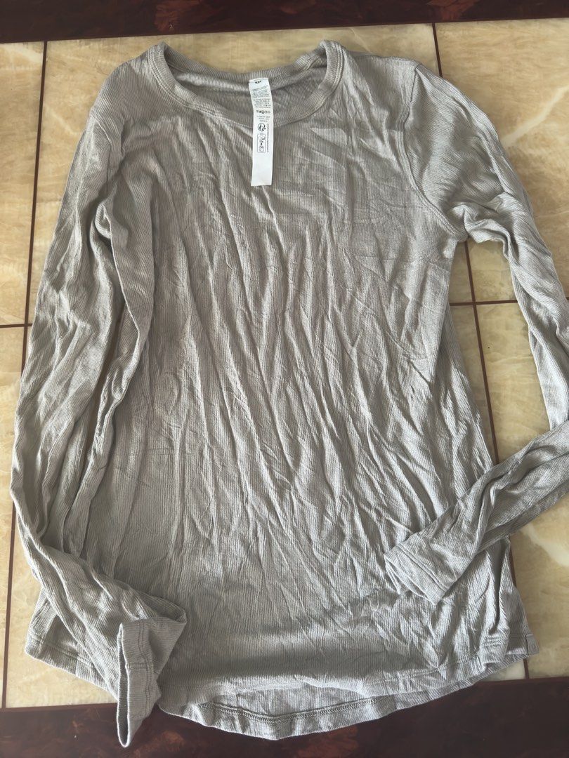 Lululemon Long Sleeve Ribbed Top Size 10 Grey (Category: Longsleeves) located in Manila. Submitted by jessj30 (Listing ID 1468958537, Image 1). Description: - Brand: Lululemon - Item: Ribbed Long Sleeve Top - Color: Grey - Size: 10 (Tag attached) - Material: 94% Lenzing Modal, 6% Elastane - Features: Crew neckline, long sleeves, signature subtle logo tab near hem - Origin: Made in Vietnam - Condition: Brand new with tag.