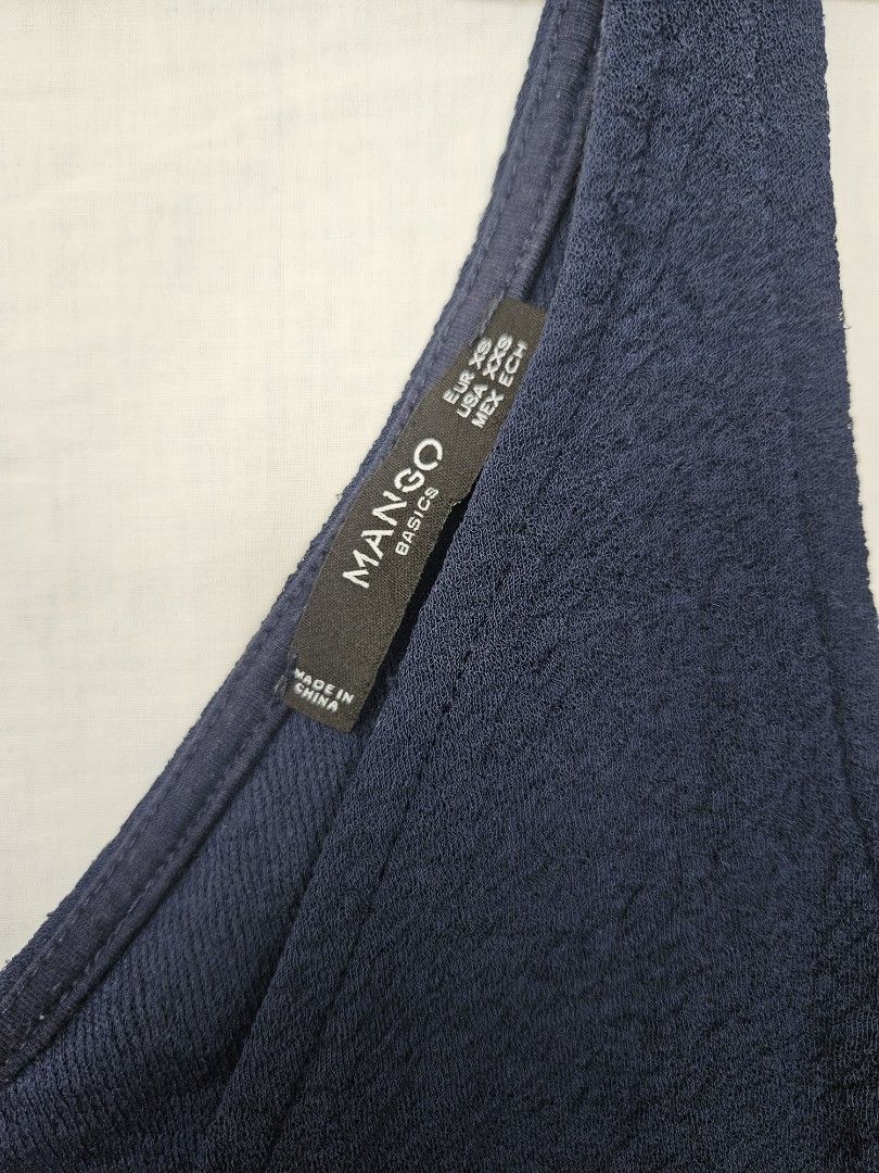 Mango Basics Navy Blue Tank Top Size XS (Category: Sleeveless) located in Quezon City. Submitted by _pcloset (Listing ID 1469005358, Image 3). Description: - Brand/Style: Mango Basics navy blue sleeveless tank top - Neckline: V-neck cut on both front and back - Material: Lightweight, textured fabric with slight stretch.
