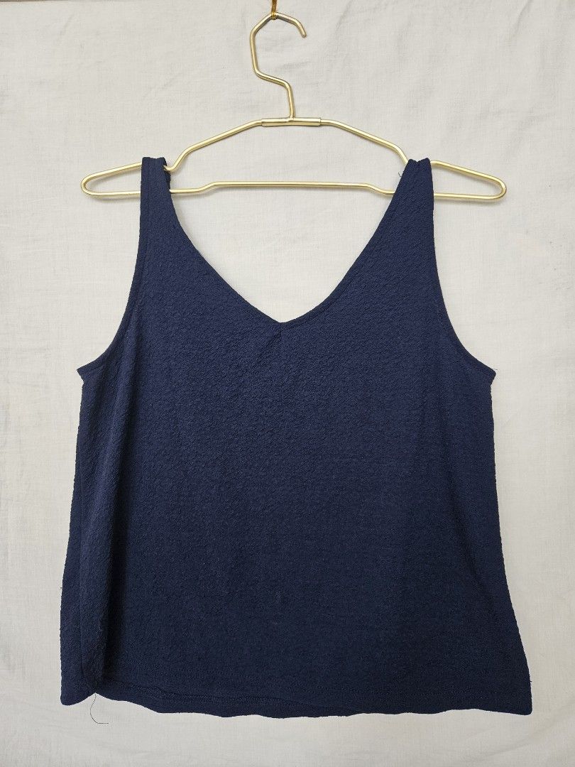 Mango Basics Navy Blue Tank Top Size XS (Category: Sleeveless) located in Quezon City. Submitted by _pcloset (Listing ID 1469005358, Image 2). Description: - Brand/Style: Mango Basics navy blue sleeveless tank top - Neckline: V-neck cut on both front and back - Material: Lightweight, textured fabric with slight stretch.