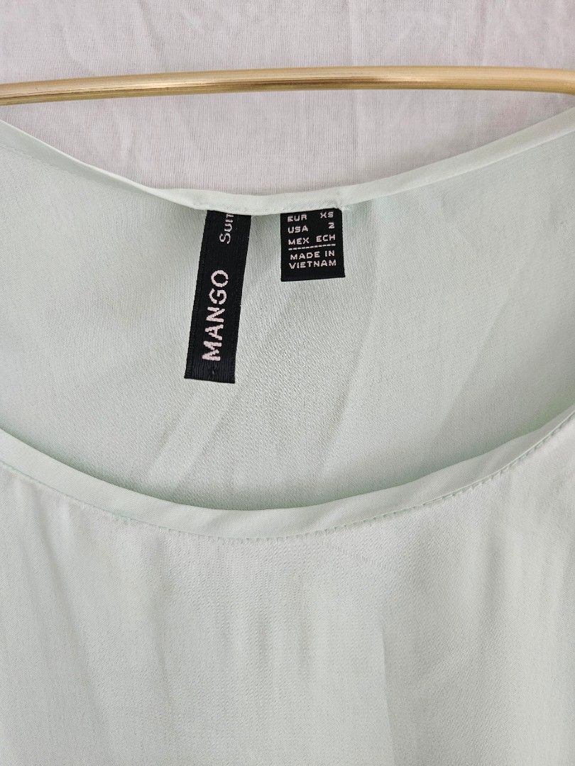 Mango Green Short Sleeve Blouse (Category: Blouses) located in Quezon City. Submitted by _pcloset (Listing ID 1469005363, Image 2). Description: - Brand: Mango - Color: Mint Green - Fit: Relaxed fit with a scoop neckline and curved hem - Fabric: Soft, lightweight material - Style: Versatile for casual days or office wear.