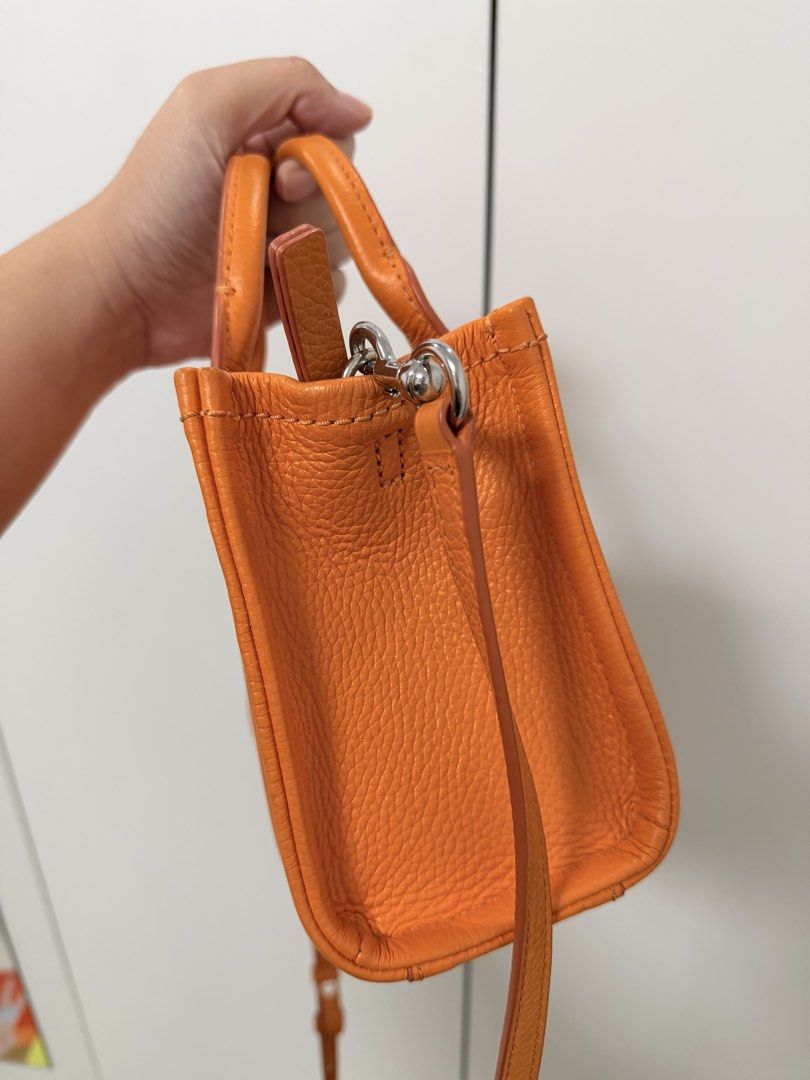 Marc Jacobs Scorched Micro Leather Bag (Category: Luxury Bags & Wallets) located in Cebu City. Submitted by yllxco (Listing ID 1469155249, Image 3). Description: Marc Jacobs Scorched Micro Leather Bag 🧡 Color: Orange Preloved bag with visible signs of use. Please check the photos carefully for the actual condition and details. Details: • Brand: Marc Jacobs • Model: Scorched Micro Leather Bag • Color: Orange • Material: 100% Calfskin Leather • Si