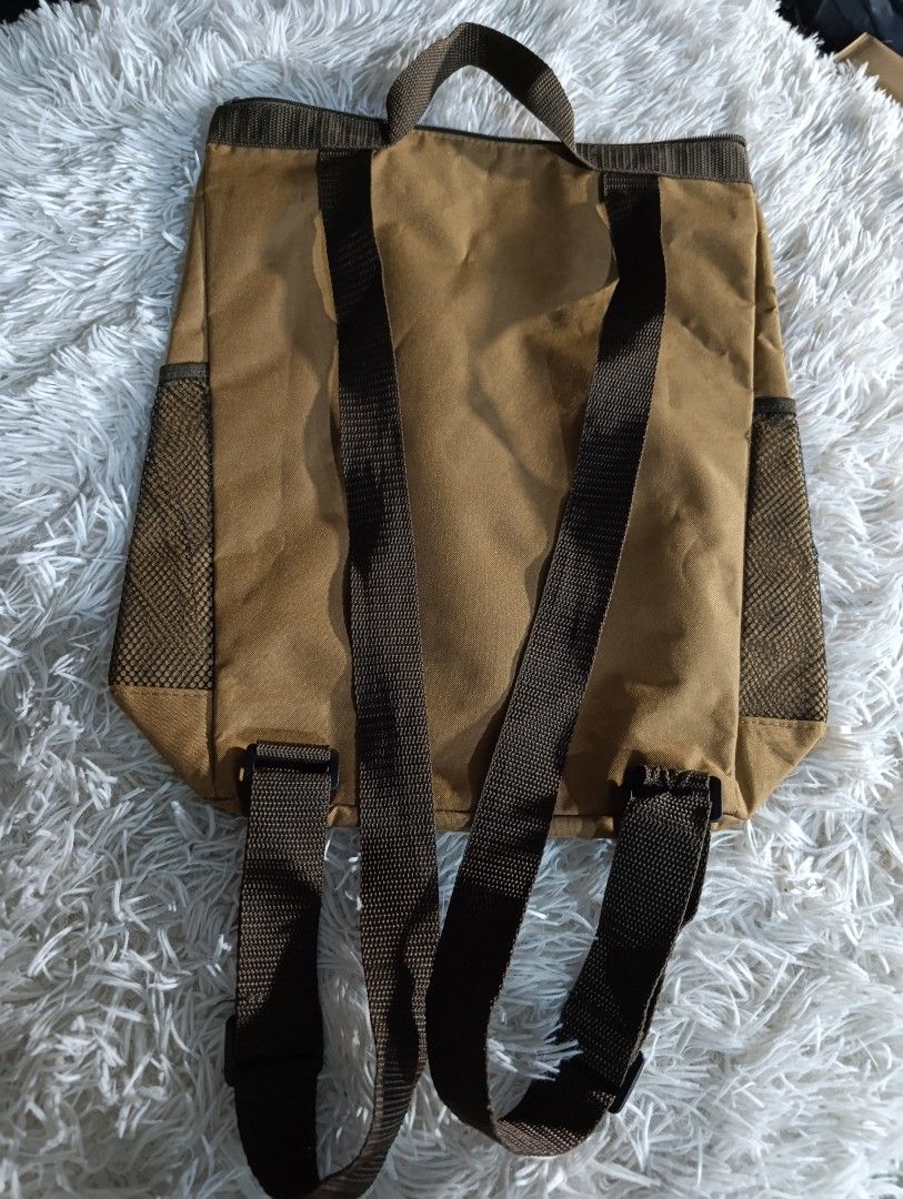 Marmot Brown Backpack Tote Bag with Mesh Side Pockets (Category: Backpacks) located in Bacoor. Submitted by MommahAnnaOnlineShop (Listing ID 1469131368, Image 2). Description: • Functions as both a hand-carry tote bag and a backpack with adjustable straps. • Includes an internal insulated/cooler lining designed to hold items like up to three 2-liter plastic bottles. • Features side mesh pockets and a prominent white Marmot logo on a brown body. •
