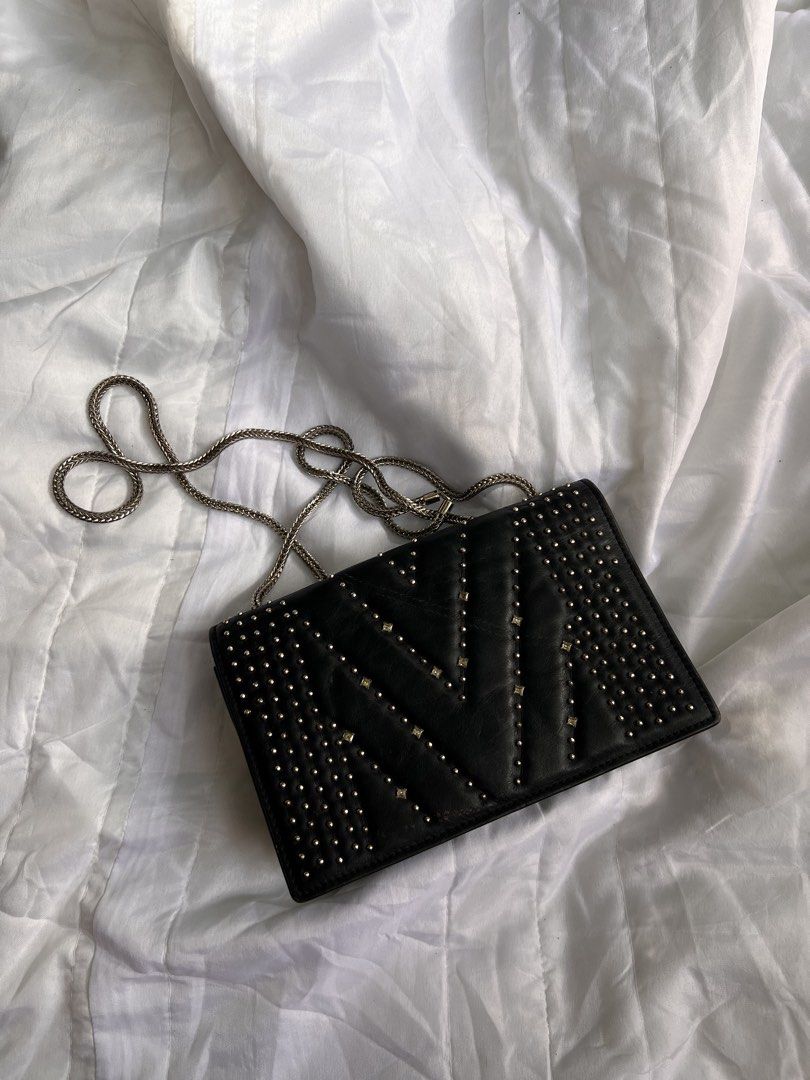 MCM Studded Black Leather Crossbody Bag (Category: Luxury Bags & Wallets) located in Quezon City. Submitted by rizza14ortiz (Listing ID 1468960632, Image 1). Description: Black leather crossbody bag from MCM. Silver tone studs in V patterns across the front. Silver chain strap attached through metal grommets. Back zipped pocket with metal plate displaying the MCM logo. Red leather interior lining with magnetic closure. Shows minor scratches on th