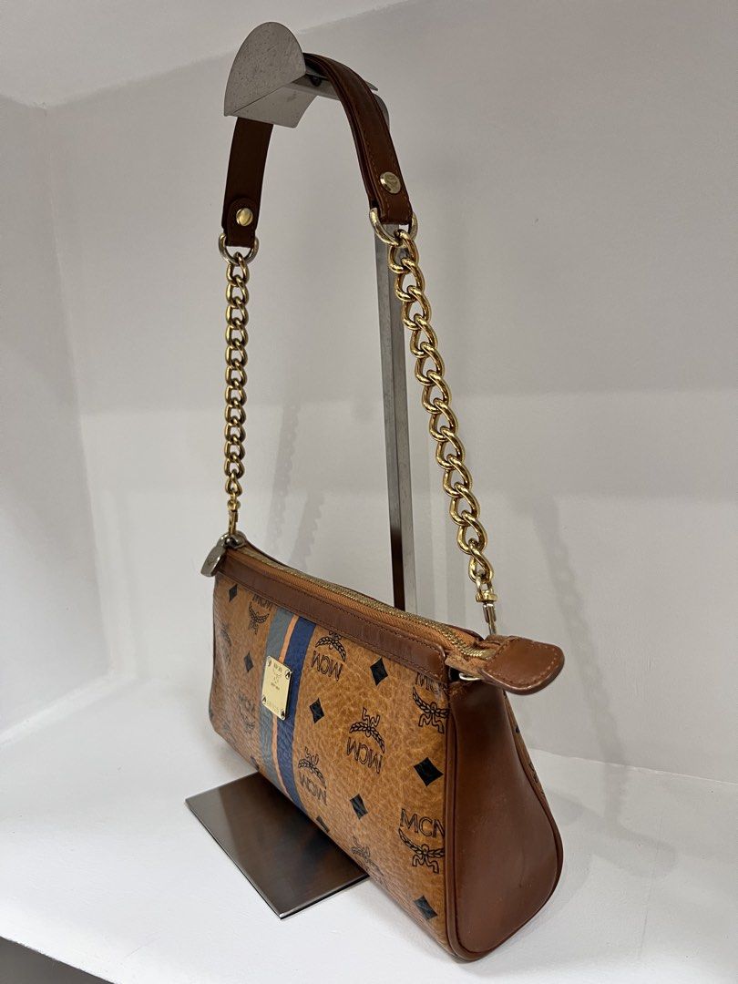 MCM Visetos Delmy Monogram Stripe Shoulder Bag Brown (Category: Luxury Bags & Wallets) located in San Jose del Monte. Submitted by itstokyotokyo (Listing ID 1468937541, Image 2). Description: - Authentic MCM shoulder bag in classic brown Visetos monogram coated canvas - Eye-catching blue and orange vertical center stripes on the front - Polished gold-tone metal logo plate with serial number G8925 - Secure top zip closure with durable brown leathe