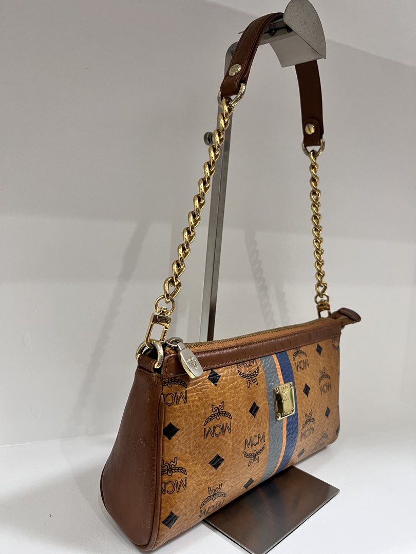 MCM Visetos Delmy Monogram Stripe Shoulder Bag Brown (Category: Luxury Bags & Wallets) located in San Jose del Monte. Submitted by itstokyotokyo (Listing ID 1468937541, Image 3). Description: - Authentic MCM shoulder bag in classic brown Visetos monogram coated canvas - Eye-catching blue and orange vertical center stripes on the front - Polished gold-tone metal logo plate with serial number G8925 - Secure top zip closure with durable brown leathe