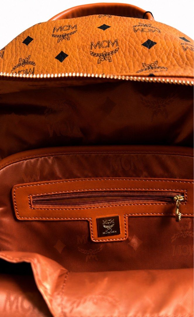 MCM Visetos Monogram Studded Leather Backpack Cognac (Category: Luxury Bags & Wallets) located in Manila. Submitted by dough_lux (Listing ID 1468959502, Image 3). Description: - Brand: MCM - Color: Cognac brown with classic monogram print - Material: Premium leather - Hardware: Gold-toned - Compartments: Front zippered pocket, interior zip pocket, spacious fabric-lined main interior - Features: Signature studded side pockets, adjustable shoulder 